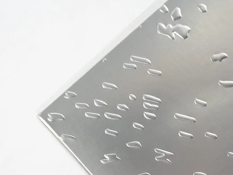 Embossed relief pattern on a metallic silver packaging sample