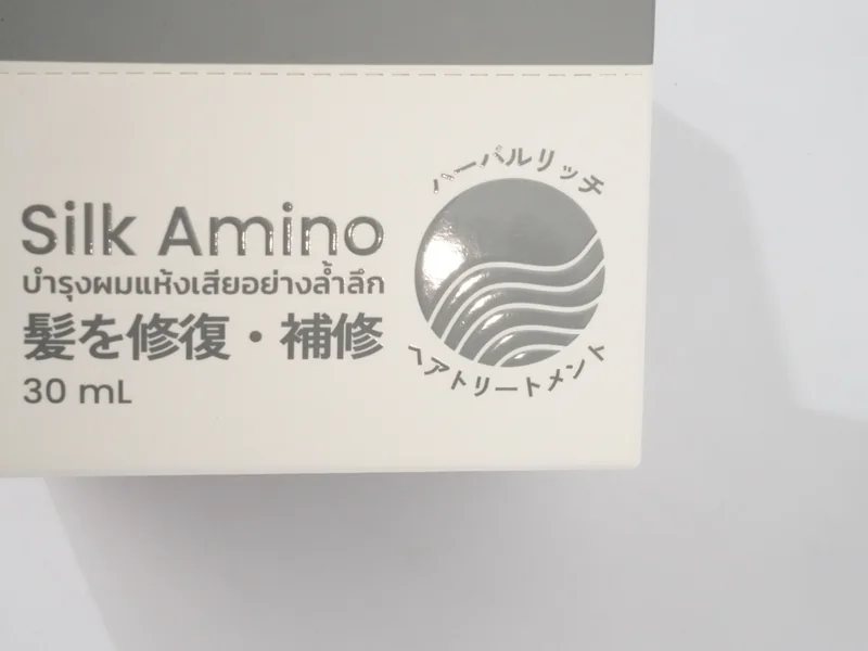 Spot UV gloss circle on a white printed carton, catching the light