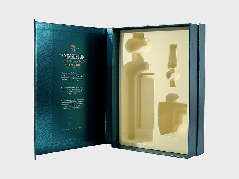 Book-style rigid box opened flat, showing the printed inner lid and a cream molded pulp insert