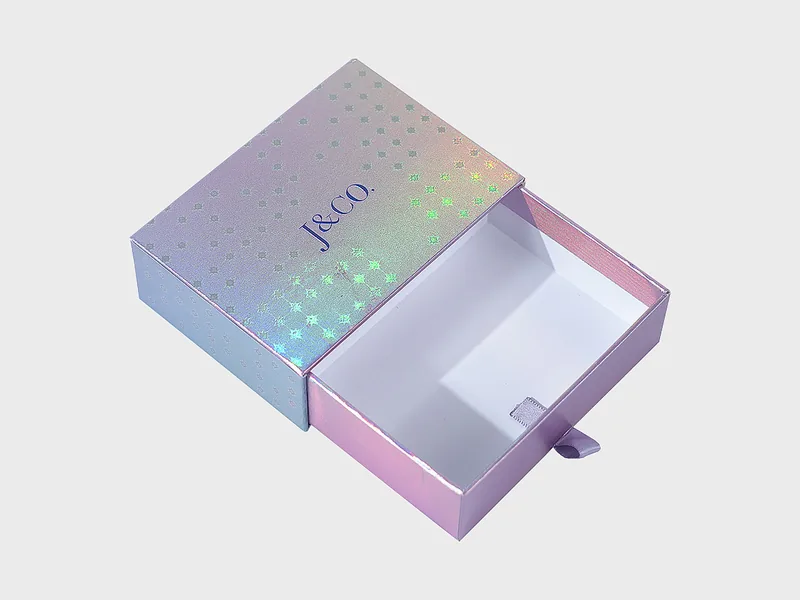 Iridescent drawer box with the drawer slid open, revealing the white inner tray and ribbon pull